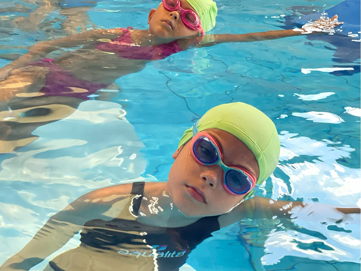 Duas crianças praticando flutuação na piscina da Aqualita BRfit